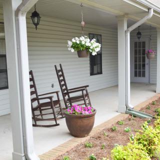 A cozy front porch with rocking chairs and vibrant flowers.