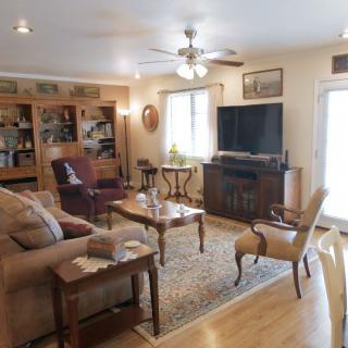 A cozy living room featuring a sofa, television, bookshelf, and coffee table.
