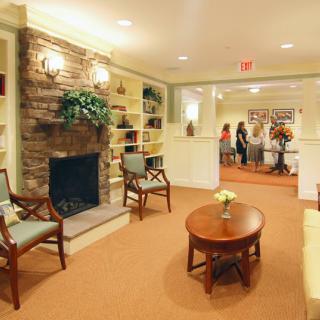 A cozy living room with a fireplace, seating, and warm lighting.