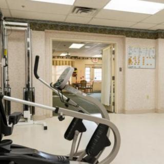 A fitness room with exercise equipment, including an elliptical machine.