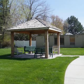 A serene gazebo in a park, surrounded by lush green grass, providing a perfect spot for relaxation.