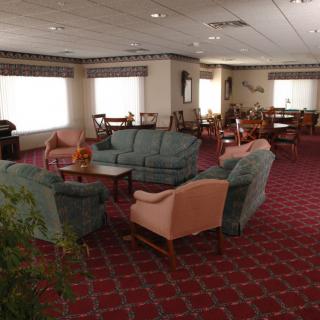 A spacious lounge area with comfortable seating and a warm carpeted floor.