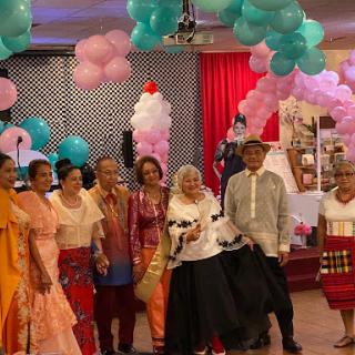 A vibrant celebration with attendees dressed in colorful cultural attire amidst festive decorations.