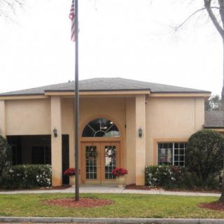 A modest building with an American flag displayed in front of its entrance.