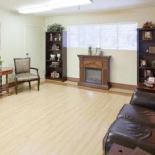 A cozy living room with a fireplace, bookshelves, and comfortable seating.