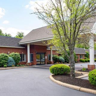 A welcoming entrance to a well-maintained facility surrounded by lush greenery.