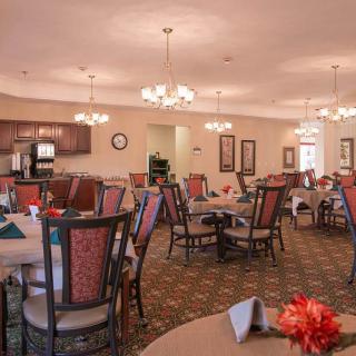 A cozy dining room with elegant decor and multiple tables set for guests.