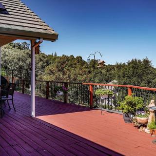 A spacious outdoor deck with patio furniture, offering a scenic view of surrounding trees and greenery.