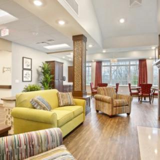 A modern and bright living room with comfortable seating and large windows.