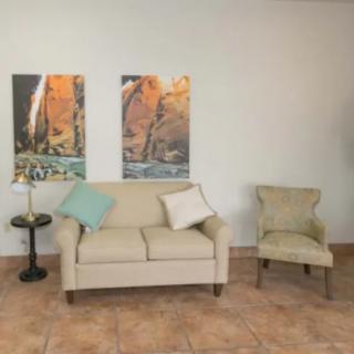 A cozy living room setup with a sofa, chair, and decorative wall art.