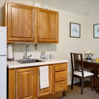 A cozy kitchen with wooden cabinets, a small dining area, and minimalist decor.