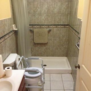 An accessible bathroom with a shower, toilet, and sink.