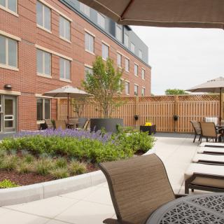 Outdoor patio area of a hotel with seating and landscaping.
