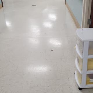 A clean hospital hallway with a storage unit on the side.