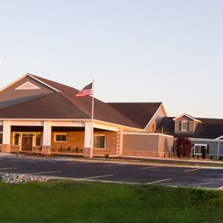 A modern building with an American flag in front, captured at sunset.