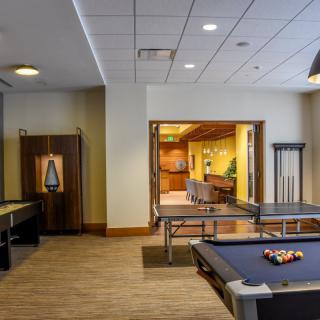 A modern game room featuring a pool table and a ping pong table, designed for recreational activities.