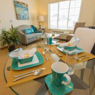 A beautifully arranged dining table with turquoise accents in a cozy living room setting.