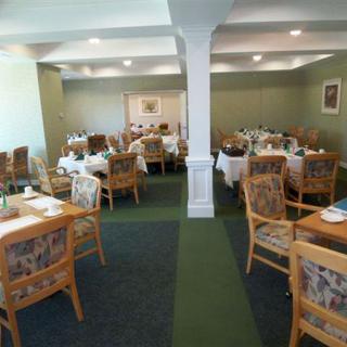 An empty restaurant dining room with neatly arranged tables and chairs.