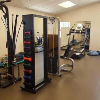 A fitness gym featuring various exercise equipment, including weights and machines.