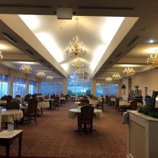An upscale restaurant interior with elegant chandeliers and neatly arranged dining tables.