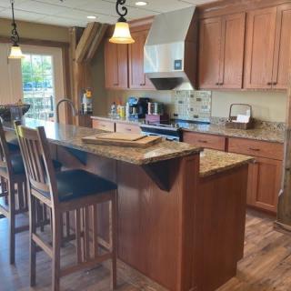 A cozy kitchen with wooden cabinets and a central island featuring bar stools.