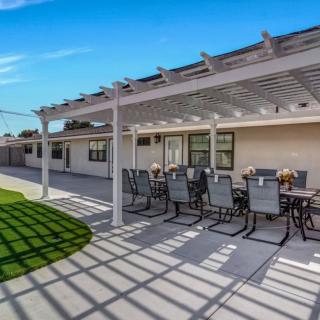A sunny backyard patio with a pergola and outdoor seating area.