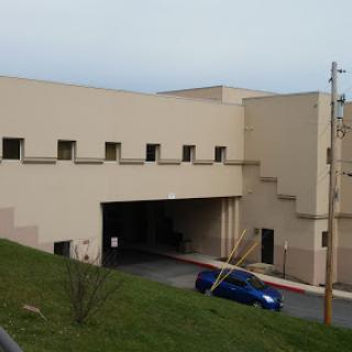 A view of a modern, beige concrete building with multiple windows.