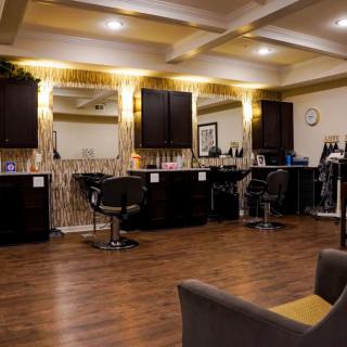 A stylish and modern salon interior with chairs, mirrors, and warm lighting.