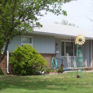A suburban house with a well-maintained front yard and tree.