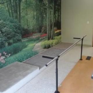 Indoor rehabilitation area with parallel bars for physical therapy.
