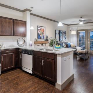 A modern open-plan kitchen and dining area with wooden flooring and stylish lighting.
