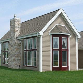 A modern residential house with large windows and a chimney.