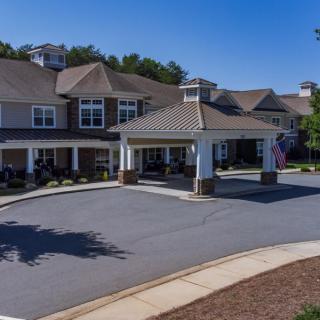 A suburban residential building with a covered entrance and landscaped surroundings.