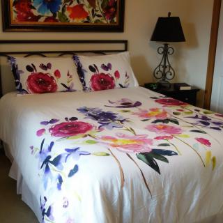 A cozy bedroom with floral bedding and stylish decor.