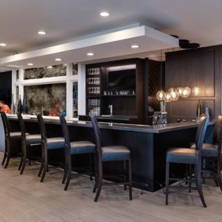 A modern bar with sleek lighting and comfortable seating.