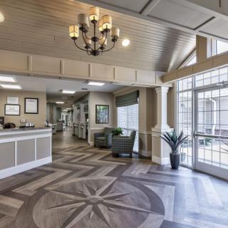 An elegant lobby with a chandelier, reception desk, and seating area.