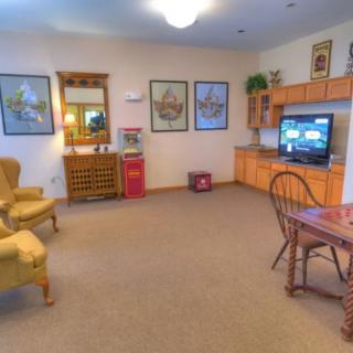 A cozy living room with comfortable chairs, a table, and a television.