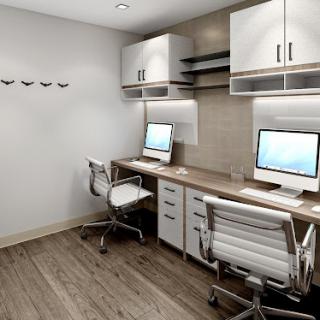 A modern office workspace featuring two desks with computers and stylish ergonomic chairs.