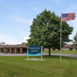 A building with a sign and an American flag on a grassy lawn.