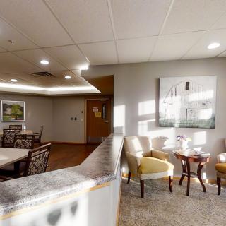 A well-lit waiting area in an office with comfortable chairs and decorative artwork.