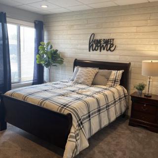 A cozy bedroom with a plaid-patterned bedspread and stylish decor.
