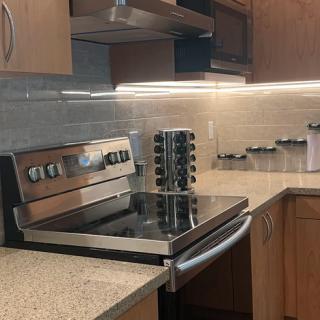 A modern kitchen with a sleek stovetop and granite countertops.