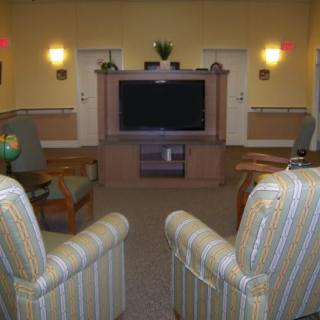 A cozy living room with comfortable chairs facing a large television.