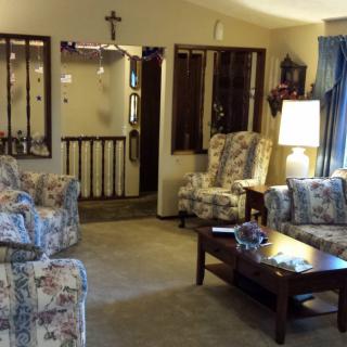 A cozy living room with floral-upholstered chairs and a wooden coffee table.