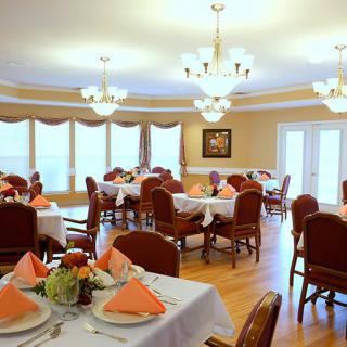 Elegant dining room with neatly arranged tables and warm lighting.