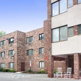 A modern brick residential building with large windows.