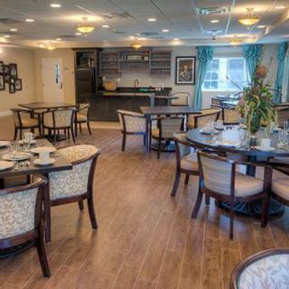 A modern dining area with neatly arranged tables and chairs, complemented by warm lighting and elegant decor.