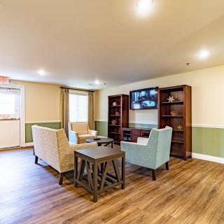A cozy living room with comfortable seating, a TV, and bookshelves.