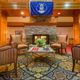 A cozy lobby with a fireplace and seating area under a decorative flag.
