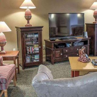 A cozy living room with a television, lamps, and comfortable furniture.